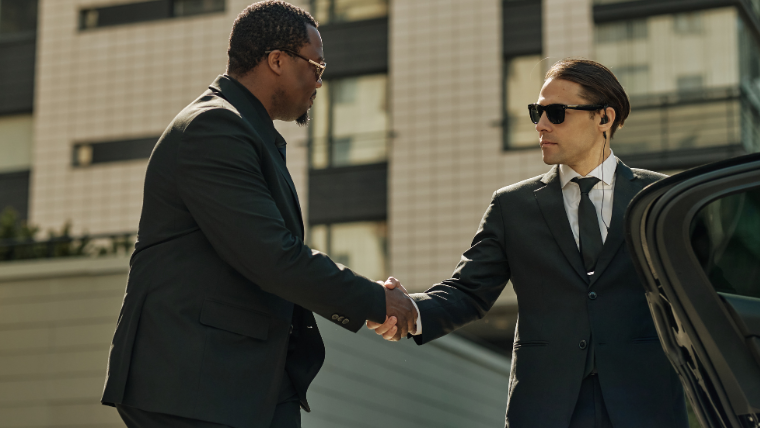 Executive chauffeur assisting business traveler at corporate ground transportation pickup in South Florid