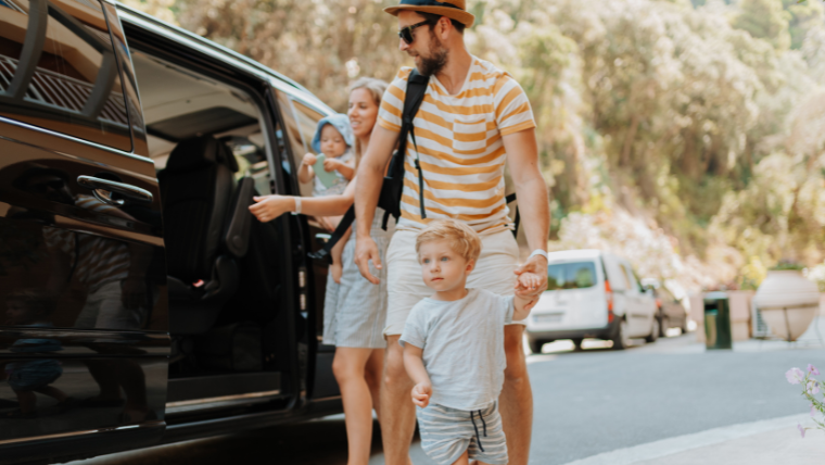 Parents and young children exiting a professional SUV car service at their South Florida destination
