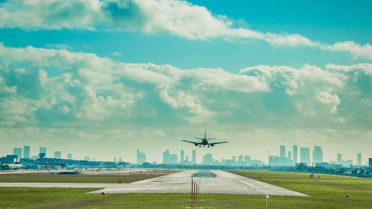 Plane landing at Fort Lauderdale-Hollywood International Airport with the Miami skyline in the background