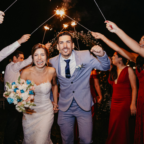 Newlyweds making their grand exit through a sparkler tunnel at their South Florida wedding reception