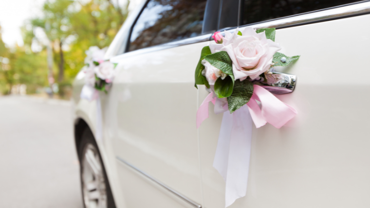 Luxury white sedan decorated for wedding day outside South Florida venue